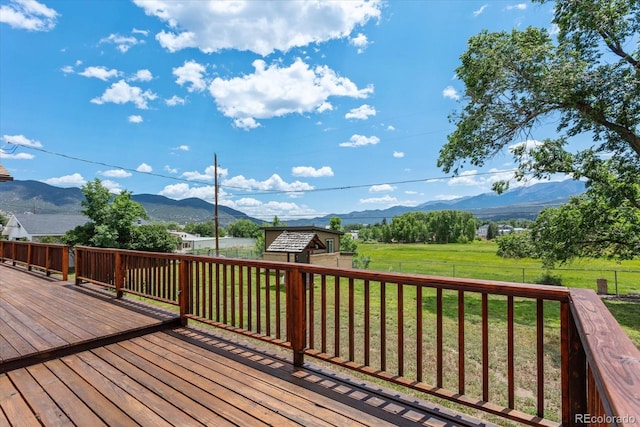 wooden terrace with a mountain view and a yard