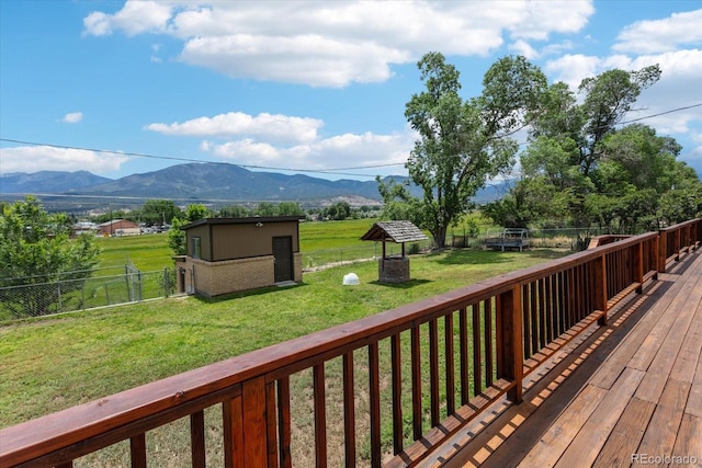 deck with a lawn, a mountain view, and a shed