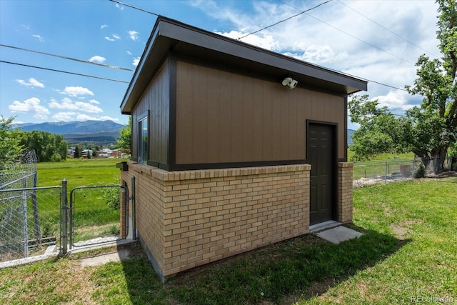 view of outbuilding with a lawn and a mountain view