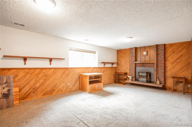 10991 E Vassar Dr, Aurora, CO 80014 - unfurnished living room featuring wood walls, carpet, a wainscoted wall, a textured ceiling, and a fireplace
