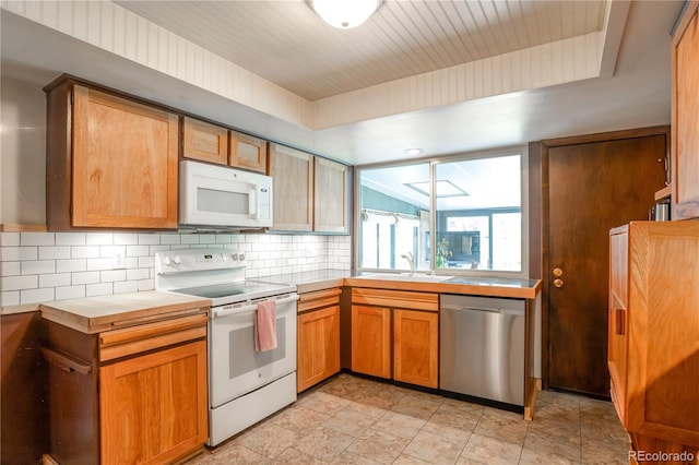 10991 E Vassar Dr, Aurora, CO 80014 - kitchen with white appliances, backsplash, a sink, tile countertops, and light stone finish floors