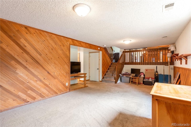 10991 E Vassar Dr, Aurora, CO 80014 - carpeted living room with stairs, wooden walls, and a textured ceiling