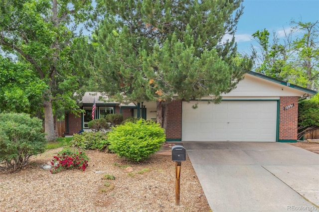 10991 E Vassar Dr, Aurora, CO 80014 - view of front of property featuring brick siding, a garage, and concrete driveway