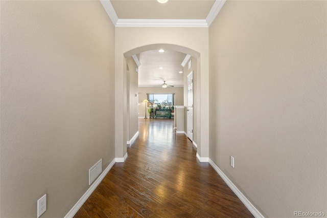 corridor featuring dark wood finished floors, visible vents, arched walkways, and ornamental molding