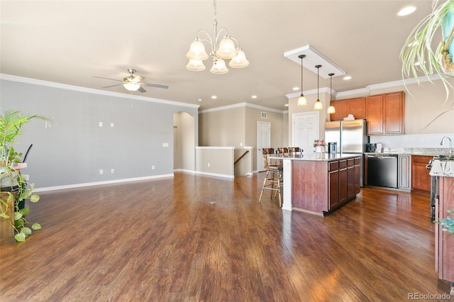 kitchen featuring a kitchen island, a breakfast bar area, hanging light fixtures, dark wood-style floors, and stainless steel appliances