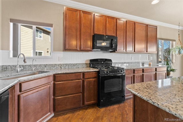 kitchen featuring a sink, crown molding, light stone counters, black appliances, and dark wood-style flooring