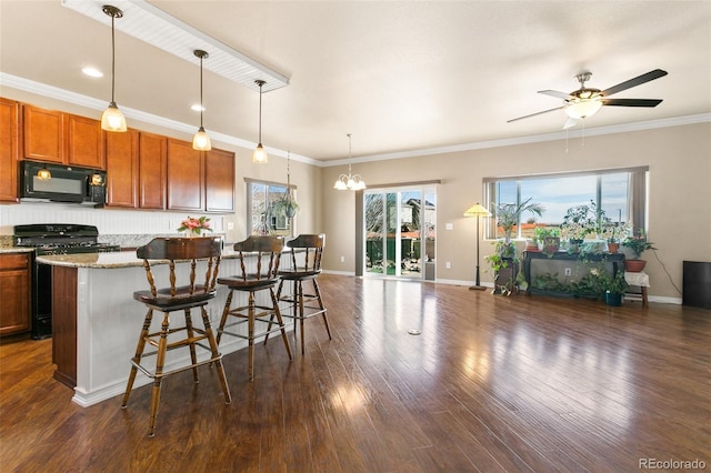 kitchen with pendant lighting, black appliances, dark wood-style floors, open floor plan, and crown molding