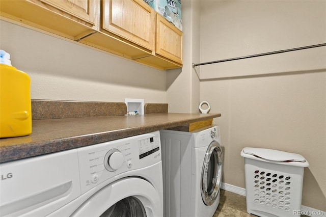 washroom featuring cabinet space, washer and dryer, and baseboards