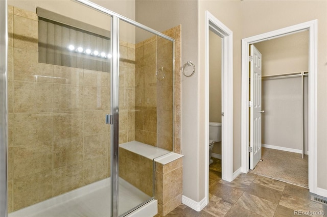 full bath with toilet, baseboards, and a stall shower