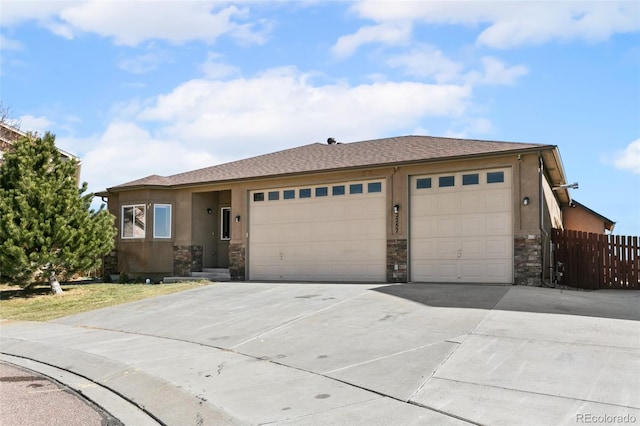 ranch-style house with fence, an attached garage, stucco siding, concrete driveway, and stone siding