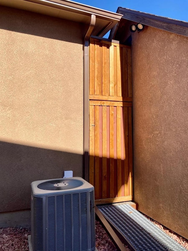 exterior details featuring cooling unit and stucco siding