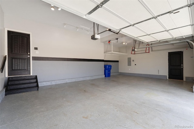 garage featuring a garage door opener, electric panel, and baseboards