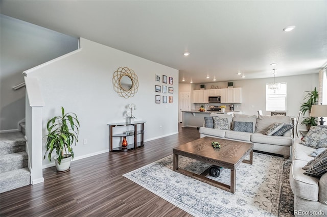 living room with dark wood-type flooring and a chandelier