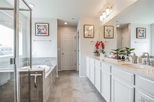 bathroom with tile patterned flooring, vanity, and separate shower and tub