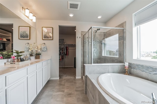 bathroom with tile patterned floors, vanity, and plus walk in shower