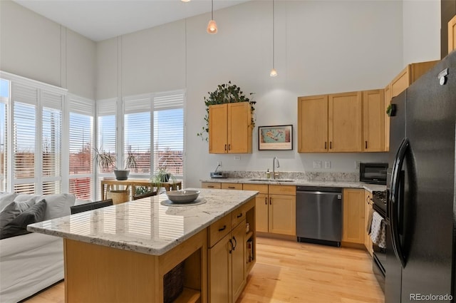 1438 Little Raven St Unit 407, Denver, CO 80202 - kitchen with black appliances, a sink, light wood-style flooring, a towering ceiling, and light brown cabinetry