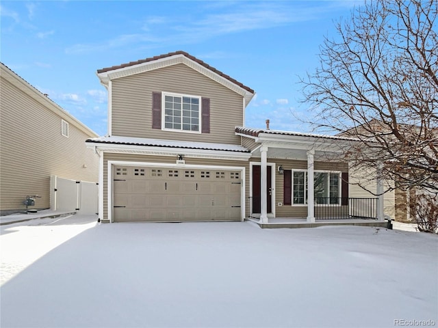 view of property with covered porch and a garage