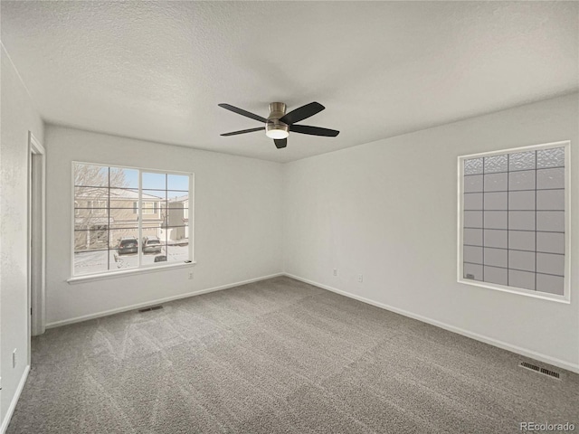 unfurnished room featuring carpet flooring, ceiling fan, and a textured ceiling