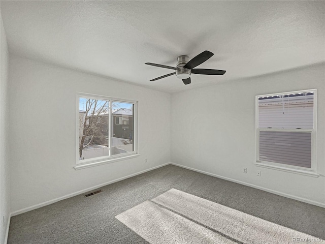 carpeted empty room featuring ceiling fan and a textured ceiling