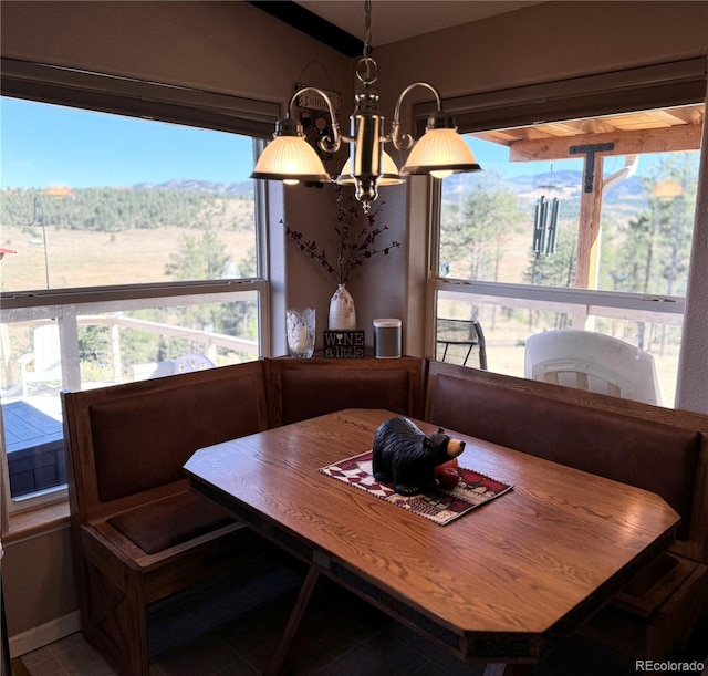 dining space with tile patterned floors, a notable chandelier, breakfast area, and a mountain view