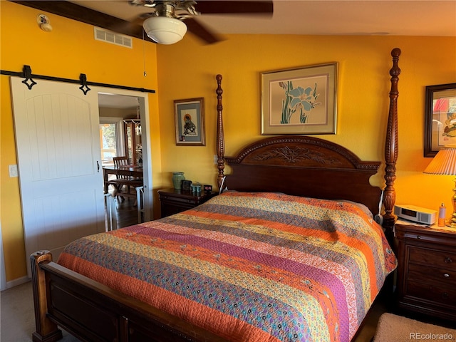 bedroom featuring a barn door, carpet flooring, vaulted ceiling, and ceiling fan