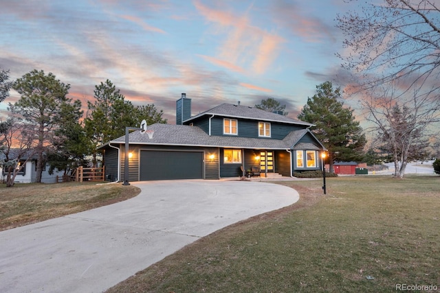 view of front facade featuring driveway, roof with shingles, a front yard, a garage, and a chimney