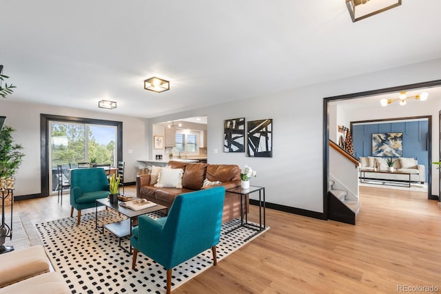 living room featuring baseboards, stairs, and light wood-style floors