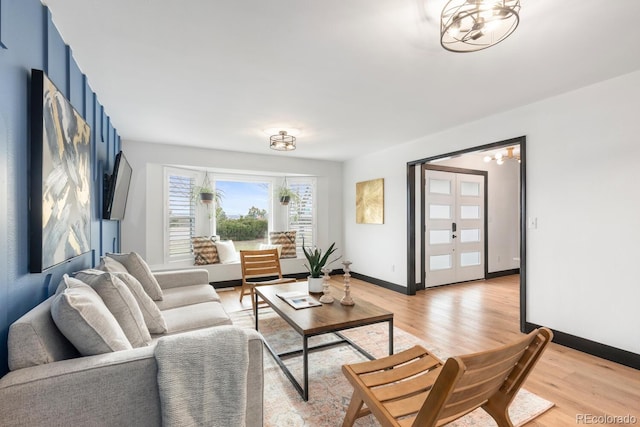 living area featuring baseboards and light wood finished floors