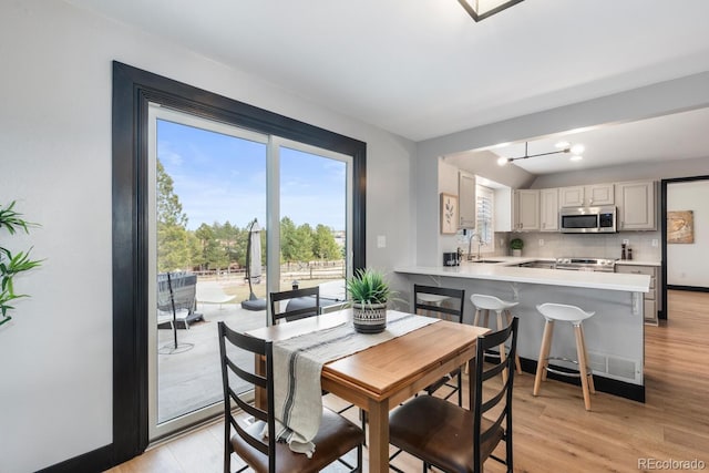 dining area featuring baseboards and light wood-type flooring