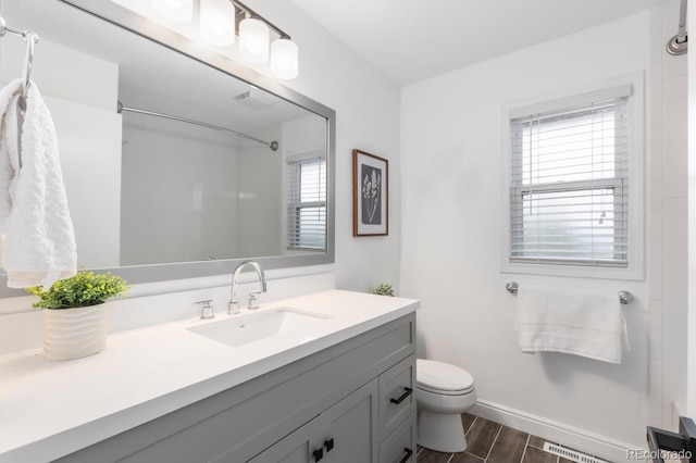 bathroom with visible vents, baseboards, wood finish floors, toilet, and vanity