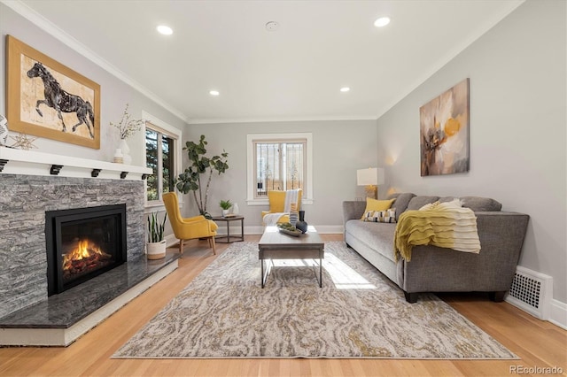 living room featuring hardwood / wood-style floors, a fireplace, and crown molding