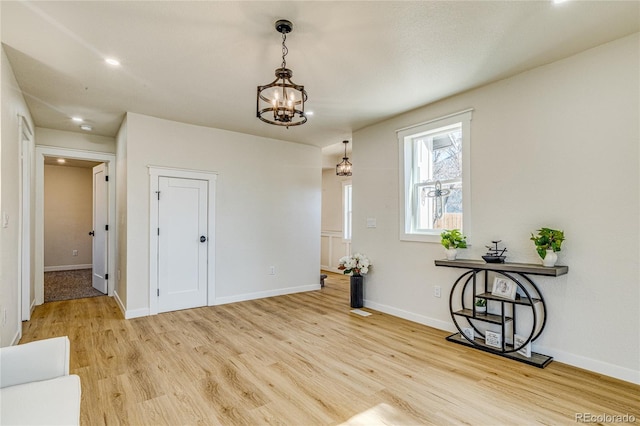 interior space featuring an inviting chandelier, wood finished floors, baseboards, and recessed lighting