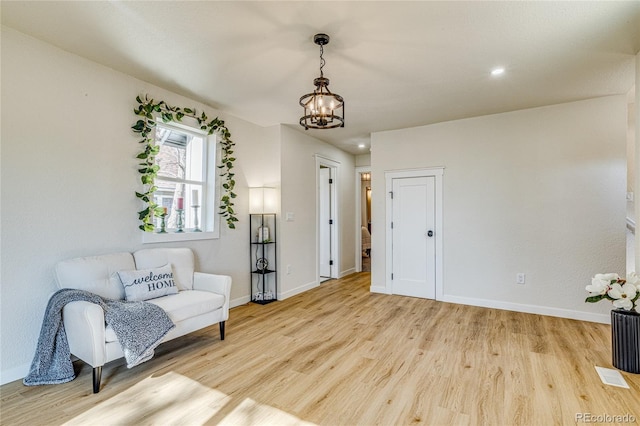 sitting room with light wood finished floors, a chandelier, baseboards, and recessed lighting