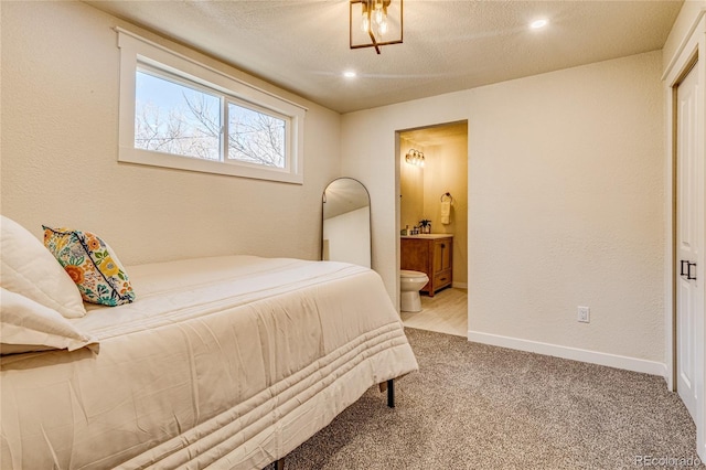 carpeted bedroom with baseboards, ensuite bathroom, and recessed lighting