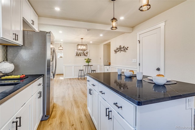 kitchen featuring white cabinets, dark countertops, and light wood-style floors