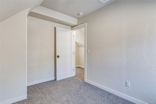 interior space featuring baseboards, a textured ceiling, and a textured wall