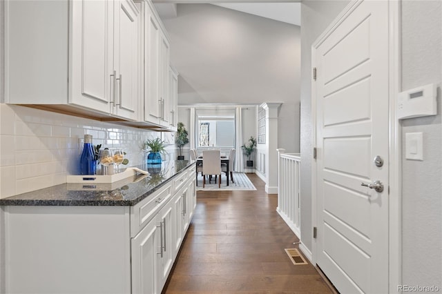 bar featuring dark wood-style floors, baseboards, visible vents, and decorative backsplash