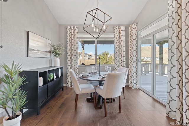 dining area with dark wood-style floors and an inviting chandelier