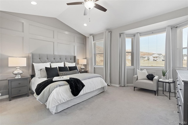 bedroom featuring light carpet, multiple windows, a decorative wall, and lofted ceiling