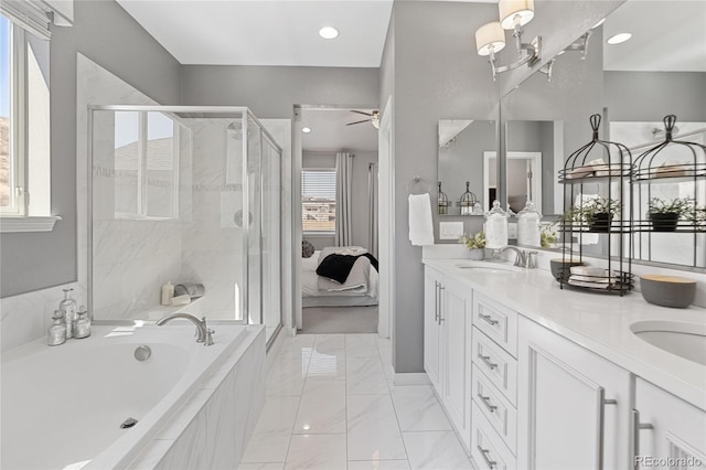 ensuite bathroom featuring a bath, a stall shower, double vanity, and a sink