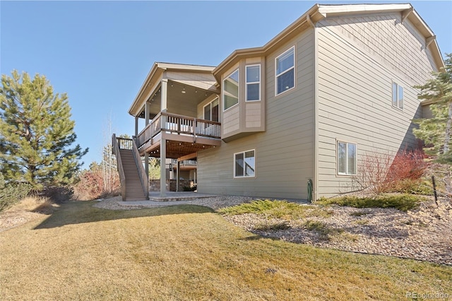 rear view of house with stairs, a yard, and a deck