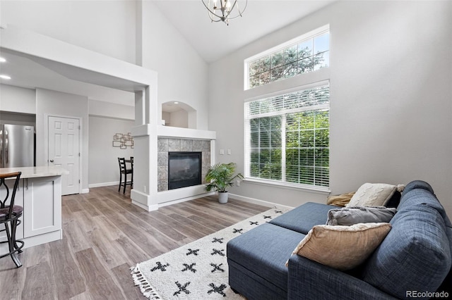 10010 E Gunnison Pl Unit 707, Aurora, CO 80247 - living area with high vaulted ceiling, light wood-style floors, healthy amount of natural light, baseboards, and a tile fireplace
