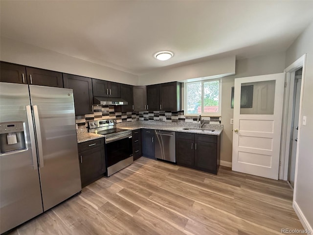 8307 E 14th Ave, Denver, CO 80220 - kitchen with stainless steel appliances, under cabinet range hood, a sink, decorative backsplash, and light stone counters