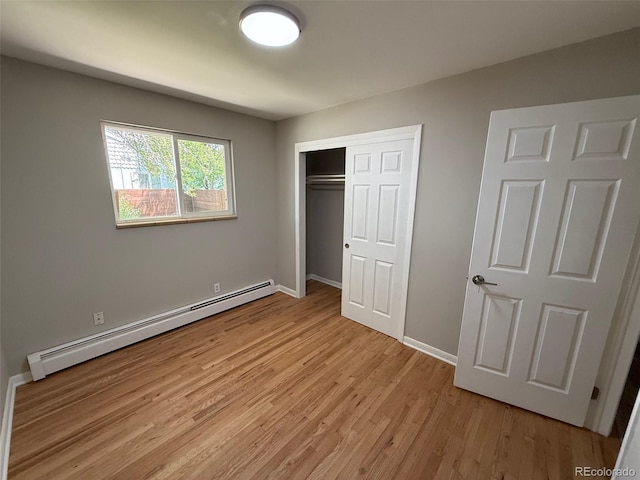 8307 E 14th Ave, Denver, CO 80220 - unfurnished bedroom featuring baseboard heating, light wood-style floors, a closet, and baseboards