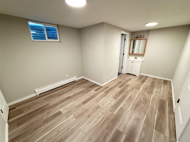 8307 E 14th Ave, Denver, CO 80220 - finished below grade area featuring baseboard heating, light wood-style flooring, and baseboards