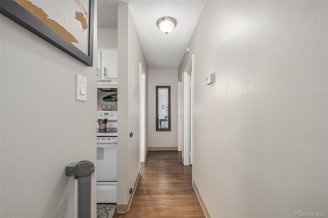 corridor featuring a textured ceiling, baseboards, and wood finished floors