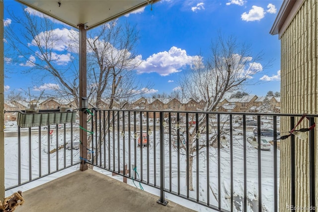 snow covered back of property featuring a residential view