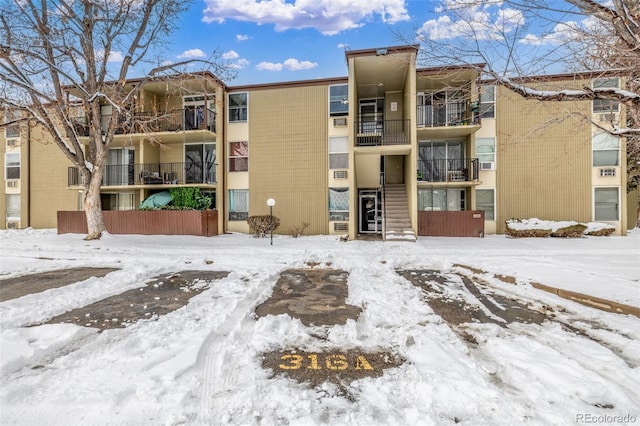 snow covered building featuring stairway