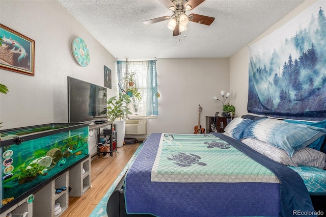 2281 S Vaughn Way Unit 316A, Aurora, CO 80014 - bedroom with a textured ceiling, wood finished floors, ceiling fan, and a wall unit AC