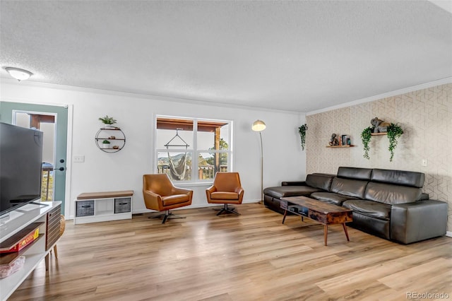 living room with baseboards, wood finished floors, a textured ceiling, and ornamental molding